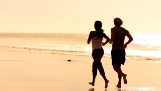 2 people running on beach